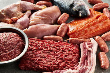 Carnivore diet or low carb diet background concept. Raw animal meat products beef, minced pork and sausages, chicken with dorado fish and salmon. High protein. Close up