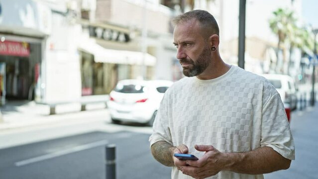 Cheerful young man, immersed in digital connection, delightfully using his smartphone on a lively city street