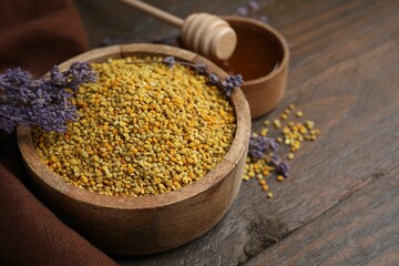 Fresh bee pollen granules and lavender on wooden table, closeup. Space for text