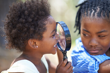 Kids, nature and magnifying glass in a forest for face, inspection or discovery in search together....