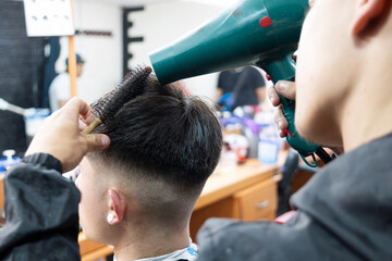 a young man drying the hair of a young man