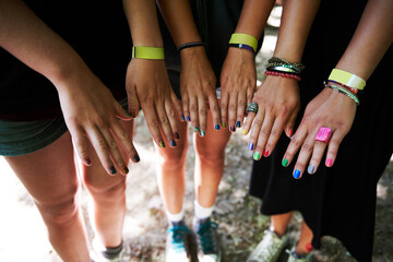 Hands, manicure and woman friends at music festival together, in a circle outdoor closeup from...
