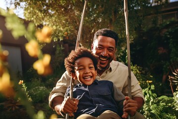 Father's Day. Diverse black dad with his son on a swing in backyard garden, smiling and looking happy, spending quality time together.