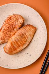 Delicious fresh grilled chicken fillet with spices and herbs on a dark concrete background