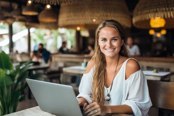 Papier Peint photo Bali Young Blonde Freelancer With Laptop in a Cafe in Bali, Indonesia
