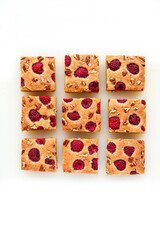 Blondies with raspberries and pecan nuts. White background. Top view