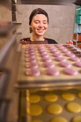 Smiling pastry chef preparing batch of cookies for baking