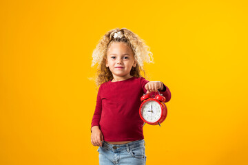 Young girl holding an alarm clock, symbolizing time management, education, school, and the urgency...