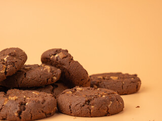Chocolatey, rich cookies with contrasting white chocolate chips on an orange background. Cookies with white chocolate close-up.