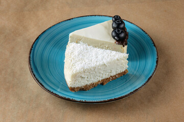 A slice of coconut cheesecake and a slice of blueberry cheesecake on a blue plate.