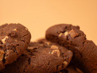 Chocolatey, rich cookies with contrasting white chocolate chips on an orange background. Cookies with white chocolate close-up.