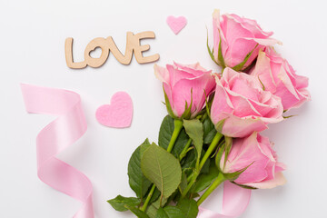 Pink roses with hearts on color background, top view. Valentines day concept