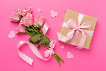 Pink roses with hearts and gift box on color background, top view. Valentines day concept