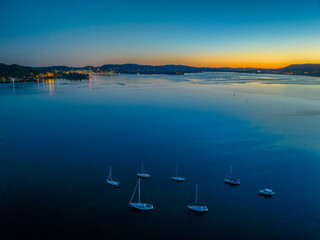 Fototapeta premium Aerial sunrise over the calm water with boats