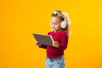 Captivating Portrait of a Joyful Kid Boy with Headphones and Tablet Immersed in Video Game Adventure. Leisure and gadget addiction concept