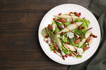 Delicious pear salad with sauce on wooden table, top view. Space for text