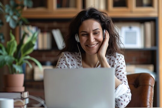 Happy Professional Mature Female Hr Manager, Smiling Mature Mid Aged Business Woman In Office Wearing Earbud Looking At Laptop Computer Having Hybrid Conference Work Meeting Or Remote Job Interview