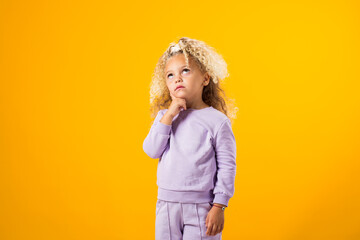 Thoughtful child girl touching chin with finger thinking or considering