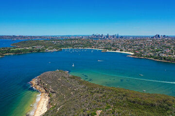 Fototapeta na wymiar High angle aerial drone view of Balmoral Beach and Edwards Beach in the suburb of Mosman, Sydney, New South Wales, Australia. CBD, North Sydney in the background, Grotto Point in the foreground.