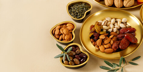 Mixed nuts and dried fruits on a gold plates. Symbols of the Jewish holiday of Tu Bishvat. Healthy snack - mix of organic nuts and dry fruits.