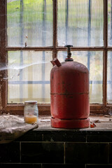 Fototapeta na wymiar an old red gas bottle on a window