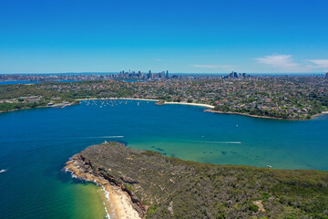 High angle aerial drone view of Balmoral Beach and Edwards Beach in the suburb of Mosman, Sydney, New South Wales, Australia. CBD, North Sydney in the background, Grotto Point in the foreground.