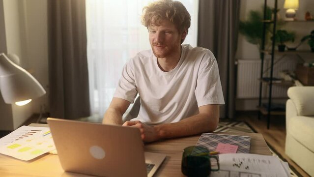 Handsome freelancer working on laptop checking email surfing web indoors Concentrated young man student having online distance education or work on computer and looking at screen at home workplace
