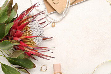 Composition with stylish female accessories and protea flower on light background, closeup