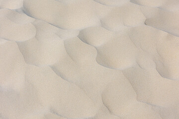 White sand on the beach in summer, Beautiful structure texture on the sand with lines or ripples,...