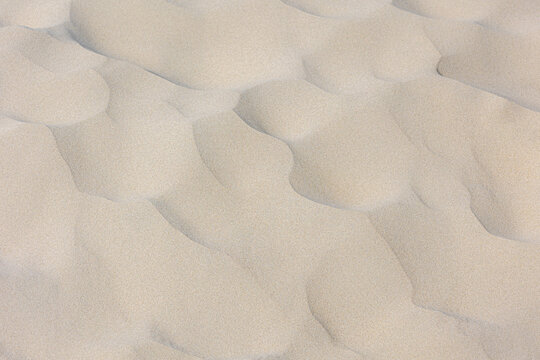White sand on the beach in summer, Beautiful structure texture on the sand with lines or ripples, Nature pattern with free copy space, Can be used as background for display or montage your products.