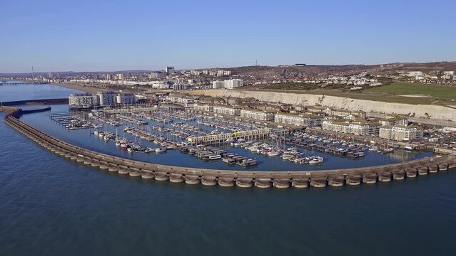 Aerial footage of Brighton Marina in East Sussex, Southern England, with chalk cliffs and Brighton City in the background.
