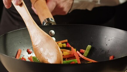 Chef cooking flambe vegetables mix on wok frying pan close-up. Color hot and sweet peppers on fire throwing them on pan. Restaurant Food concept - Powered by Adobe