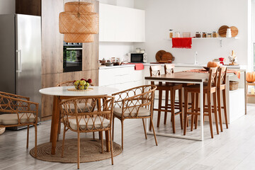 Interior of modern kitchen with tables, counters and built-in oven
