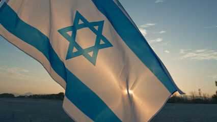 Israel national flag waving on sky background 