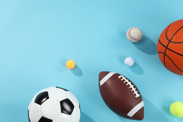 Many different sports balls on light blue background, flat lay. Space for text