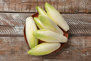 Fresh raw Belgian endives (chicory) on wooden table, top view