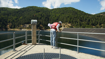 Fototapeta na wymiar Engineer inspects dam project on the balcony