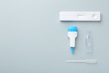 Disposable express test kit on light blue background, flat lay. Space for text