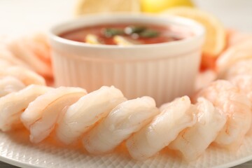 Fototapeta na wymiar Tasty boiled shrimps with cocktail sauce and lemon on plate, closeup