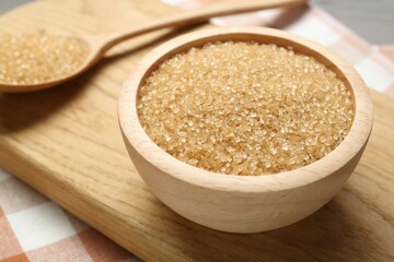 Brown sugar in bowl and spoon on table, closeup