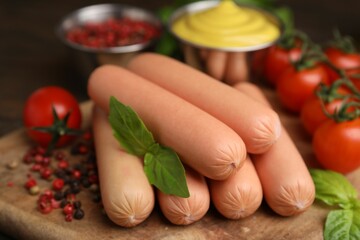 Delicious boiled sausages, tomatoes, basil and peppercorns on table, closeup