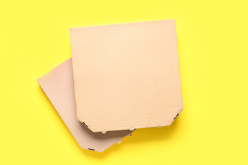 Takeaway cardboard pizza boxes on yellow background