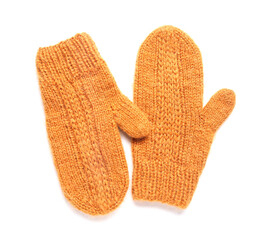 Pair of orange warm knitted mittens on white background