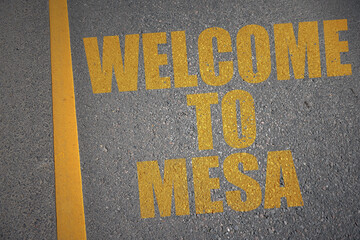 asphalt road with text welcome to Mesa near yellow line.