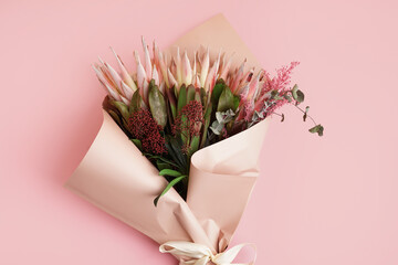 Bouquet of beautiful protea flowers on pink background