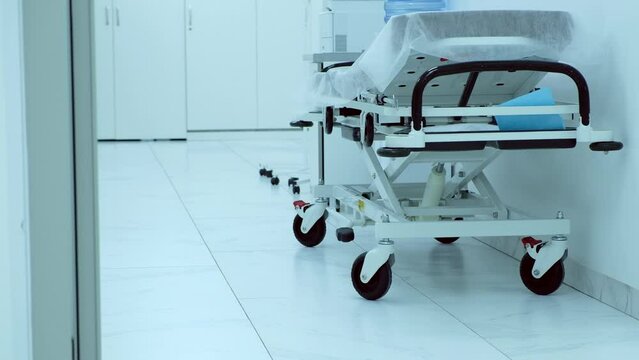 Empty corridor in a clinic with an empty bed standing