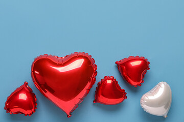 Heart shaped air balloons on blue background. Valentine's Day celebration © Pixel-Shot