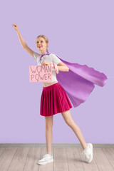 Female superhero holding paper with text WOMAN POWER near lilac wall