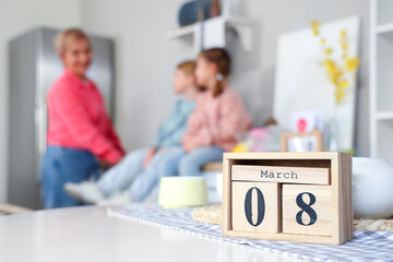 Cube calendar with date of International Women's Day on table in kitchen, closeup