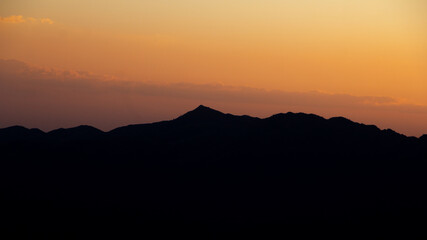 majestic distant mountain ridge silhouette during colorful sunset